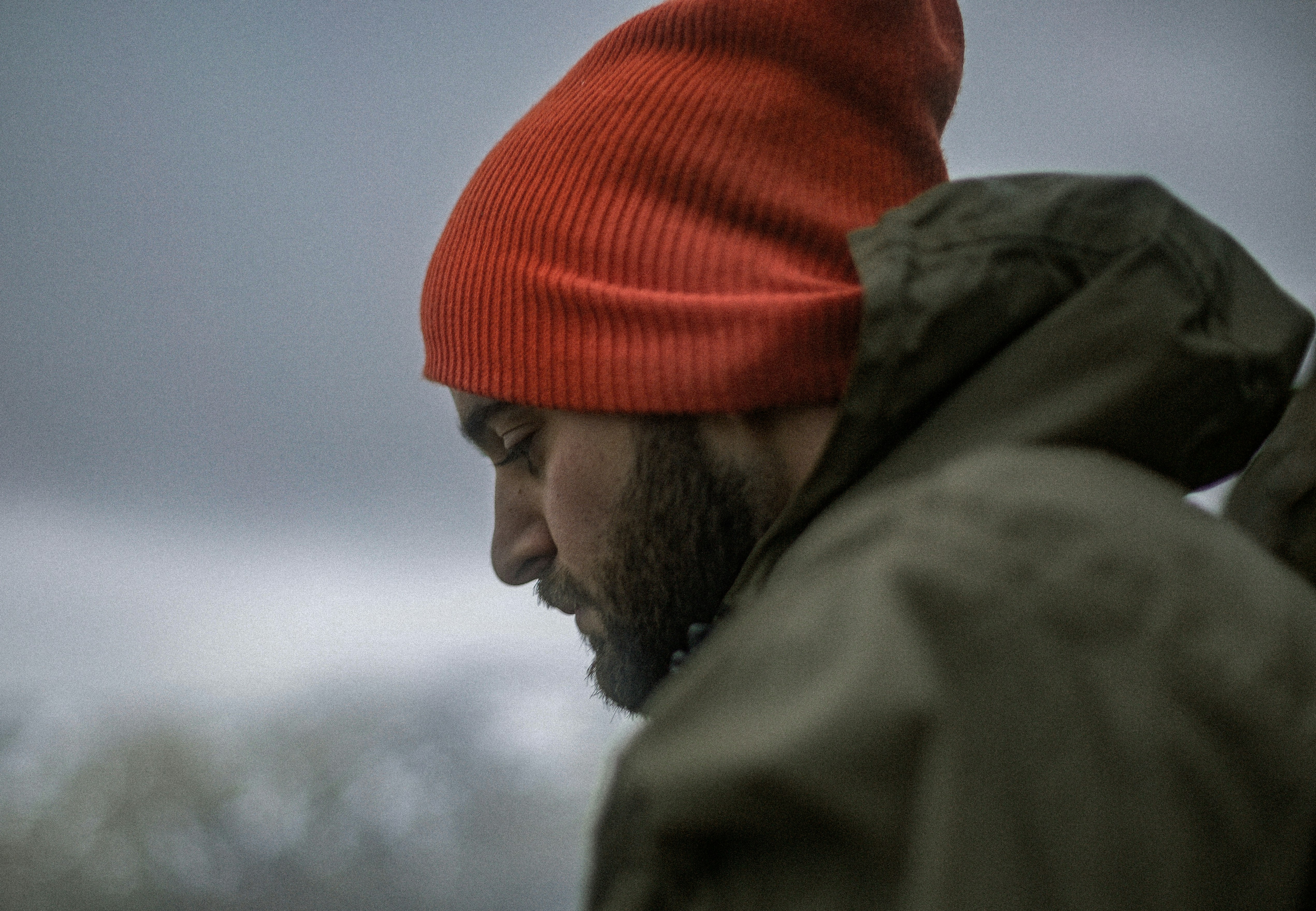 man wearing gray hoodie and orange knit cap